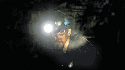 Miner Jason Hutchinson takes a moment to talk with fellow miners during an overnight shift in the Pinnacle Mine in Wyoming County, W.Va.