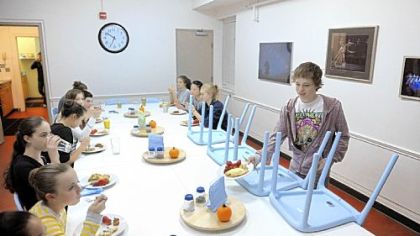 Cameron Clark puts down his plate in order to take a chair off the dinner table at the Pittsburgh Ballet Theatre's Byham House for out-of-town students.