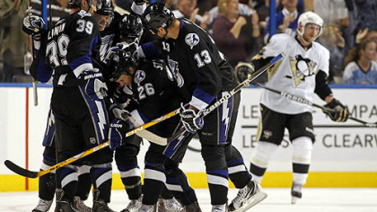 Lightning forward Martin St. Louis, No. 26, is congratulated on his goal by teammates, including, from left, Mike Lundin, No. 39, Steven Stamkos, No. 91, and Pavel Kubina, No. 31 as Penguins forward Matt Cooke skates in the background during the third period Wednesday's game at the St. Pete Times Forum in Tampa, Fla.