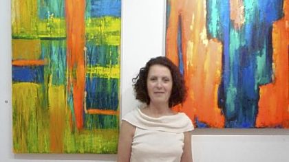 Artist Zivi Aviraz with two of her acrylic paintings, "Roman Holiday," left, and "Sedona."