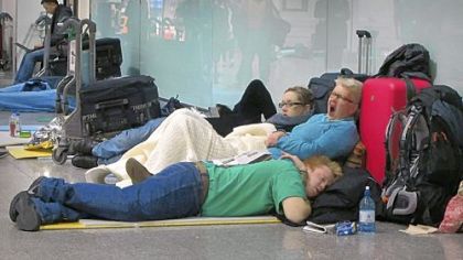 Passengers sleep on the floor as they wait for flights from Terminal 3 at Heathrow Airport in London on Tuesday. Heathrow, one of the world?s busiest airports, planned to operate with only one runway for a third day as snow continued to cause travel delays. Full service was not expected until Thursday.