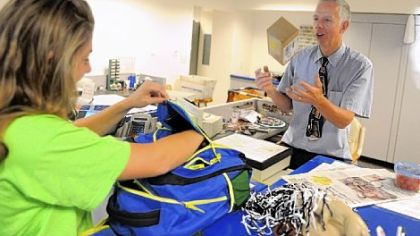 Postal clerk Mike Herr plays with a package handed to him by Penn State junior Erika Galasso, 19, at the University Park post office: "I think if you're going to be someplace for eight hours, make it fun not only for yourself but the customers."