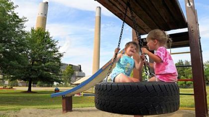 Madi Kiddey, 5, and her sister Abi, 2, play in Shippingport Community Park across the street from the Bruce Mansfield power plant in Shippingport.