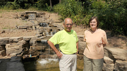 Tony Sluka of OmniPro and Janet Davis, owner of a home in Aspinwall where a  Rosetta stone waterfall was installed.
