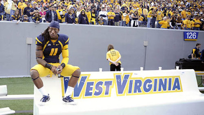 West Virginia's Bruce Irvin sits alone on the bench following a 19-14 loss against Syracuse Saturday in Morgantown, W.Va.