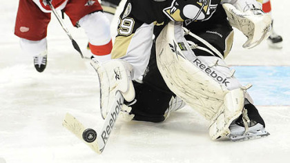 Penguins goaltender Marc-Andre Fleury steers a puck away from Red Wings forward Dan Cleary.