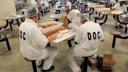 Prisoners prepare silverware for the next meal in the prison's dining hall.