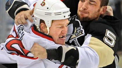 Penguins defenseman Deryk Engelland fights Senators forward Chris Neil in the first period.