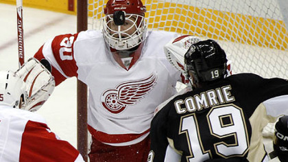 Penguins Mike Comrie prepares to collect the rebound off Red Wings goalie Chris Osgood for the first goal.