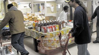 Robert Auxer, a volunteer, pushes a cart for a patron at Northside Common Ministries' food pantry.