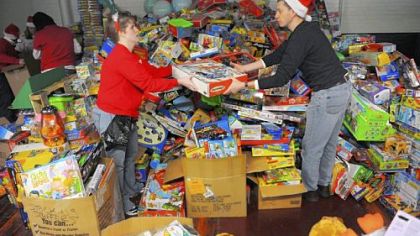Jackie Curtis of Pitcairn hands Randy Winslow of Penn Hills a toy as volunteers from CVS Caremark help sort toys for Toys for Tots at Guardian Storage Solutions in the Strip District.
