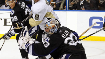 Lightning goaltender Dan Ellis,  makes a third-period save in front of teammate Mike Lundin and Penguins forward Pascal Dupuis.
