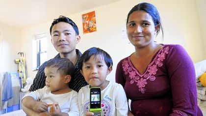 The Rai family, refugees from Bhutan, from left, Damber, son Ayush, daughter Ashmita and Gopi, in their apartment in Whitehall. Ashmita is displaying a picture she took of her brother with the family cell phone.