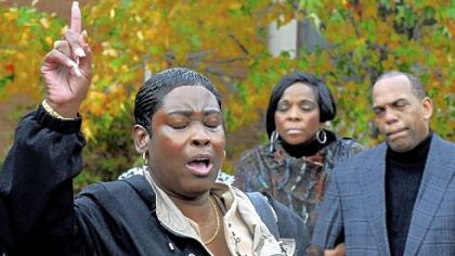 Debra Germany, executive director of Divine Intervention Ministries, points to God as she talks about the Building Bridges-Second Chances Initiative Program on Friday at Freedom Corner in the Hill District. Her son was murdered in 2001. In the background are Marsha C. Grayson and the Rev. Glenn G. Grayson, parents of 18-year-old Jeron Grayson, who was shot and killed Oct. 17.