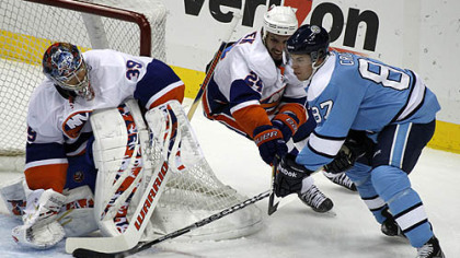 Penguins forward Sidney Crosby  cannot get a shot past Islanders goaltender Rick DePietro while under pressure from defenseman Radek Martinek in the first period.