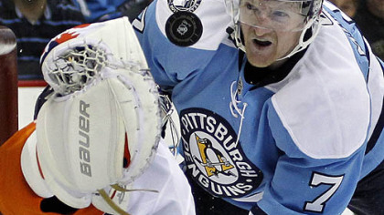 Penguins defenseman Paul Martin  watches a rebound off Islanders goaltender Rick DiPietro during the second period.