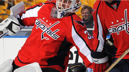 Penguins alumni Gary Rissling is knocked to the ice in front of Capitals goalie Don Beaupre during the Winter Clasic Alumni game.