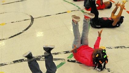 Children at the Early Childhood Education Center in Homewood kick up their legs as they follow the lead of Kerra Alexander of the Pittsburgh Ballet Co.
