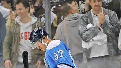 Sidney Crosby skates over one of the hundreds of hats that hit the ice after he scored an empty-net goal against the Calgary Flames to cap off his hat trick in the third period Saturday.