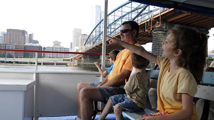 The Kudrav family rides beneath the Smithfield Street Bridge over the Monongahela River.