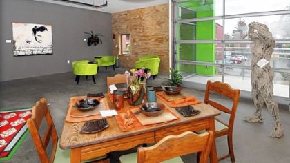 "I Love Your Long Shadow," a life-sized human figure made from old doilies on a wire frame, and 1970s-vintage table and chairs in a Glass Lofts unit designed by Christine Whispell and Nicole Capozzi of Mox Box Consulting.
