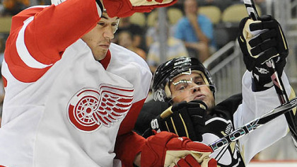 Penguins forward Mike Comrie battles Red Wings forward Jonathan Ericsson.