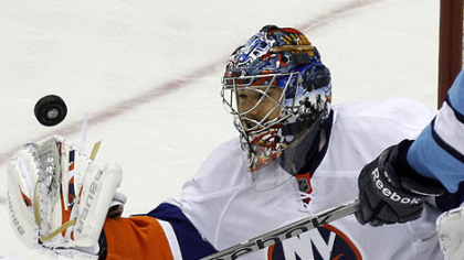 Islanders goaltender Rick DiPietro gloves a puck during overtime.