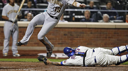 The Pirates' Chris Snyder leaps to avoid being tagged out at the plate by Mets catcher Henry Blanco on an RBI single by Andrew McCutchen during the fourth inning of tonight's game at Citi Field in New York. Snyder missed the plate in his leap and was forced to dive back, but Blanco dropped the ball on the play, allowing the run to score.
