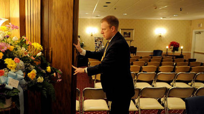 Matt Schellhaas, supervisor of Schellhaas Funeral Home in Bakerstown,pushes back the dividers to open the chapel area as he gets ready for a funeral service Thursday morning.