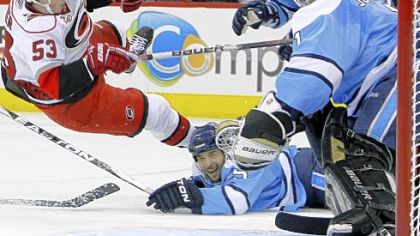 Brent Johnson, right, denies Carolina's Jeff Skinner with a little help from Deryk Engelland Saturday night in Raleigh, N.C.