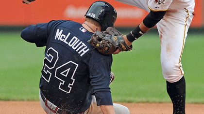 Shortstop Ronny Cedeno misses a tag on the Braves' Nate McLouth Monday afternoon.