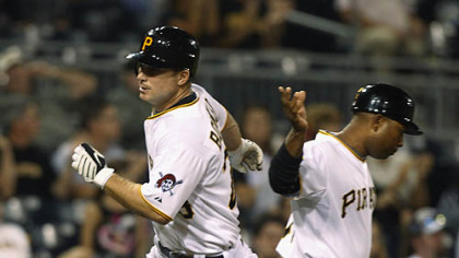 The Pirates' John Bowker, left, is greeted by third base coach Tony Beasley after hitting a solo home run in the second inning.