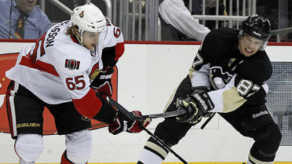 Penguins captain Sidney Crosby tries to slow Senators defensman Erik Karlsson in the second period.