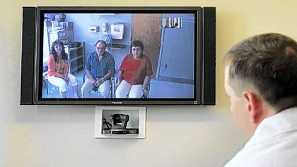 UPMC surgeon Dr. Andrew Watson, right, in his Downtown office, sees patient Robert Will and his wife, Debbie, with nurse at left.
