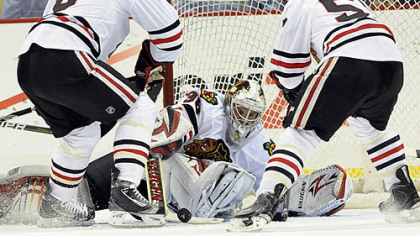 Blackhawks goaltender Alec Richards makes a save as defenseman Jassen Cullimore, left, and forward Ben Smith look to clear the puck during the first period.