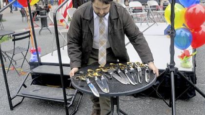 Alex Shamraevsky, a special events program coordinator from the city's Department of Parks and Recreation, sets out the oversized scissors that were used later during the ribbon cutting at the formal dedication of Market Square.