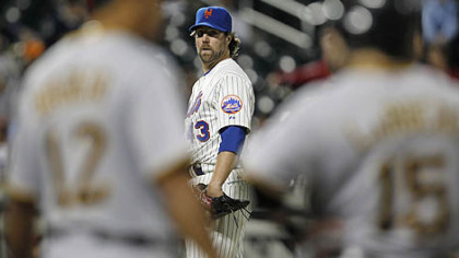 Mets starting pitcher R.A. Dickey looks toward first in the ninth inning as the Pirates' Andy LaRoche talks with first base coach Carlos Garcia.